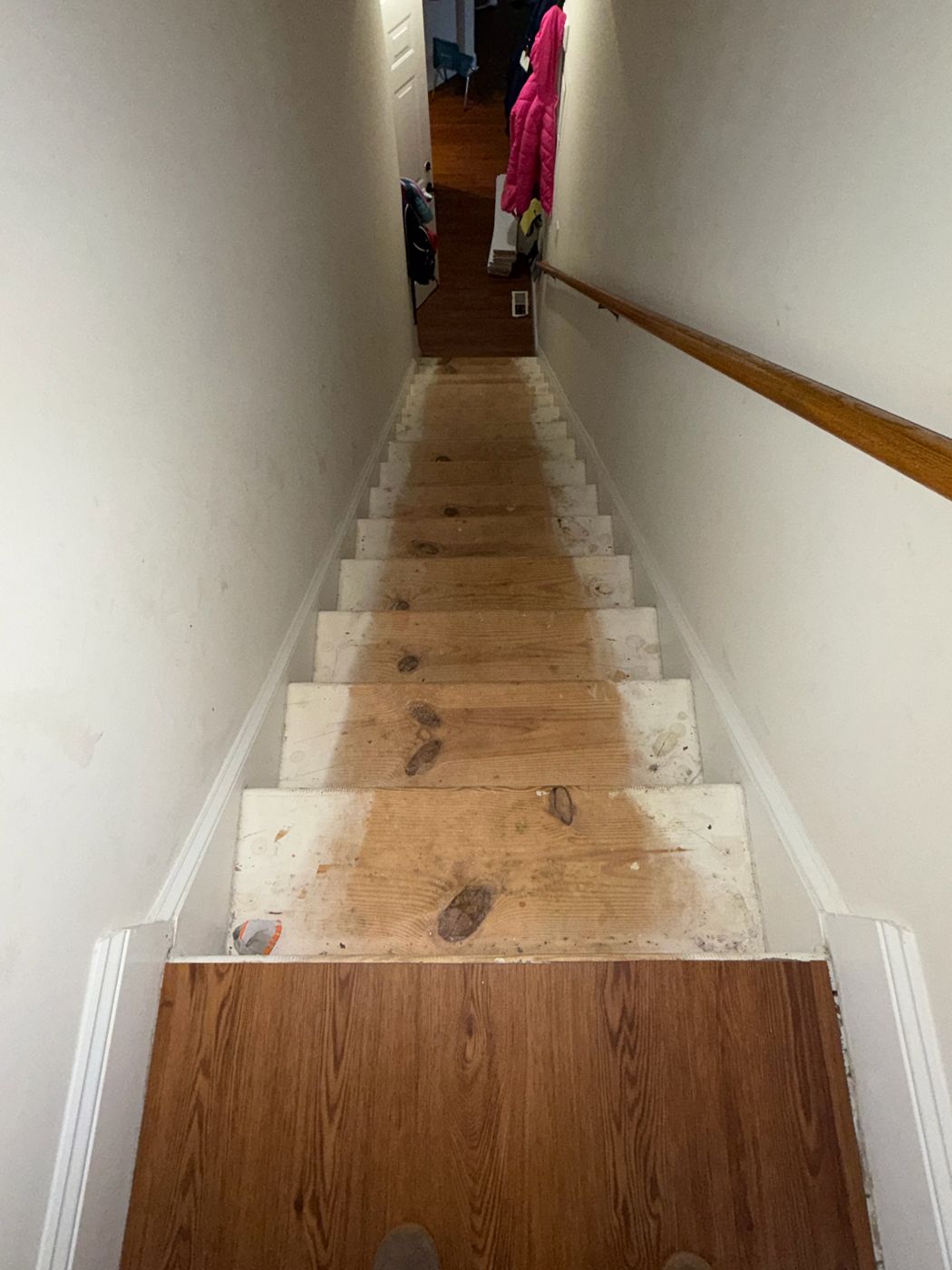 Narrow stairwell before: bare stained pine treads