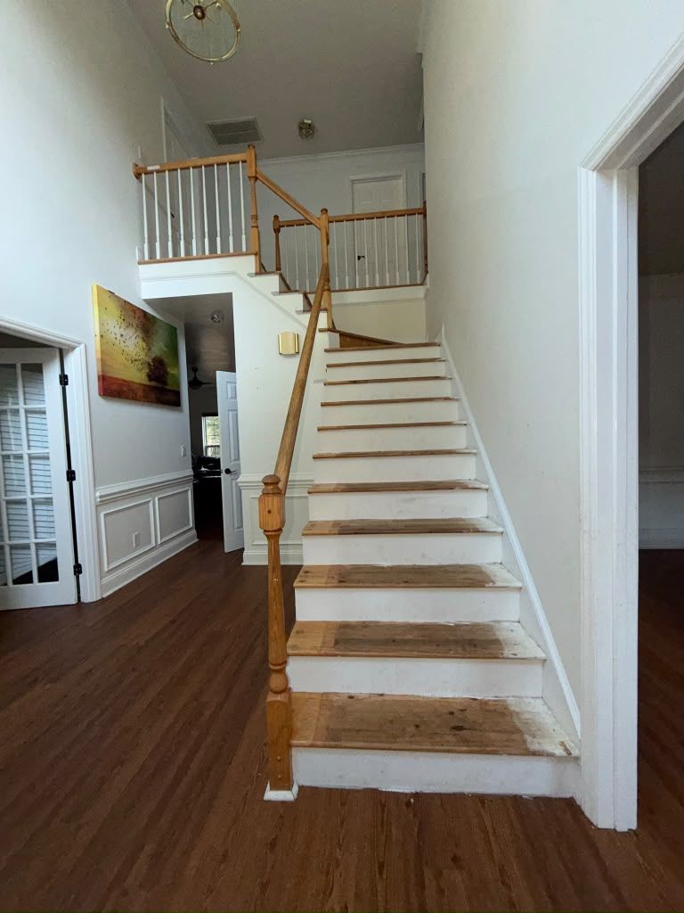 Foyer staircase before: worn treads, old oak rail with white spindles